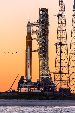 Close-up photo of the NASA SLS rocket at sunset on pad LC-39B with a flock of birds, taken on a Star Fleet boat tour